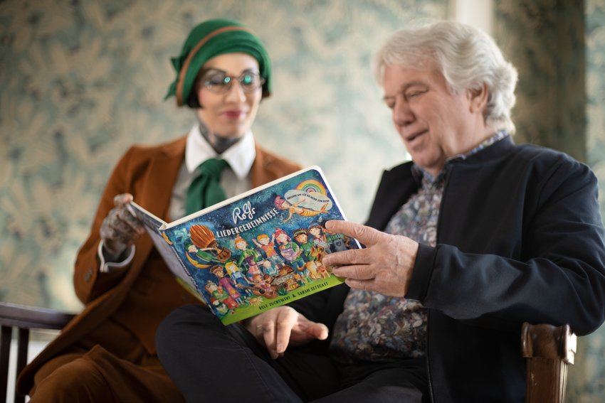 Picture of Rolf Zuckowski and Sara Settgast holding the song book